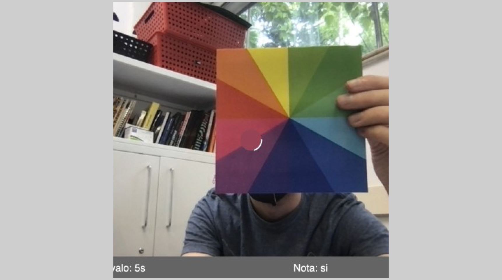 Screenshot of a person pointing a color wheel at the camera