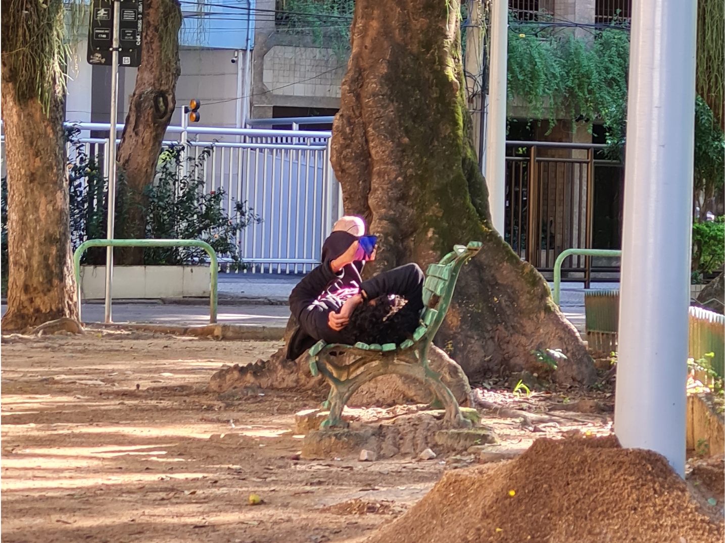 Homem deitado descansando num banco