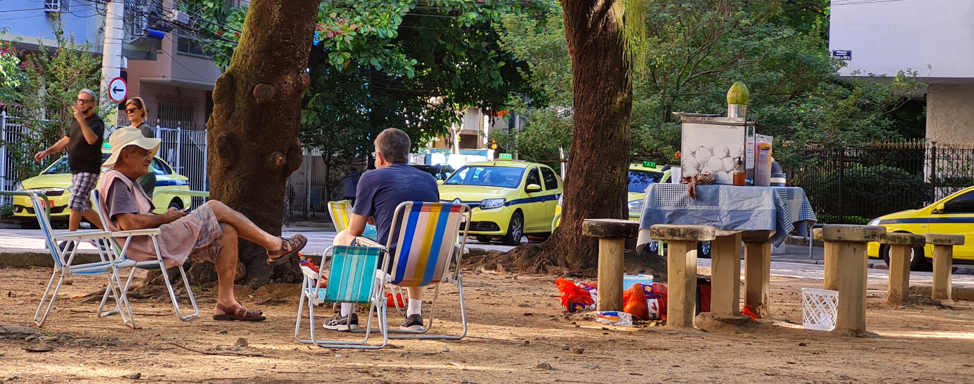 grupo em cadeiras de praia do lado de mesas vazias na praça